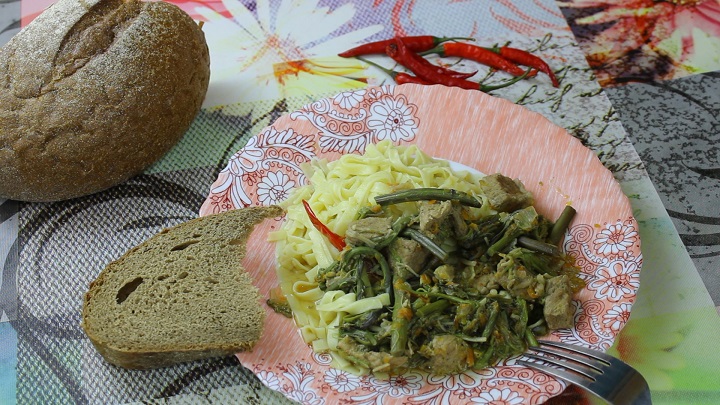 тушеная свинина с папоротником и грибами эноки, готовая порция на тарелке