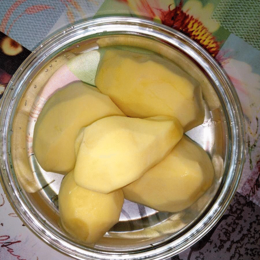 картофель очищенные клубни в воде и нарезанные пластиками